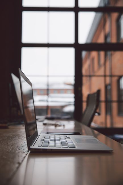 Minimalist office with a laptop on a wooden desk in front of