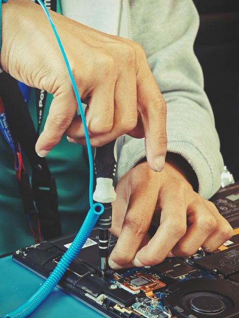 Close-up of a technician's hands repairing a laptop's intern