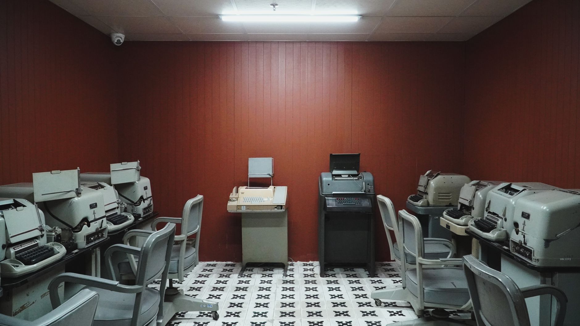 An empty room filled with vintage teletype machines and retr