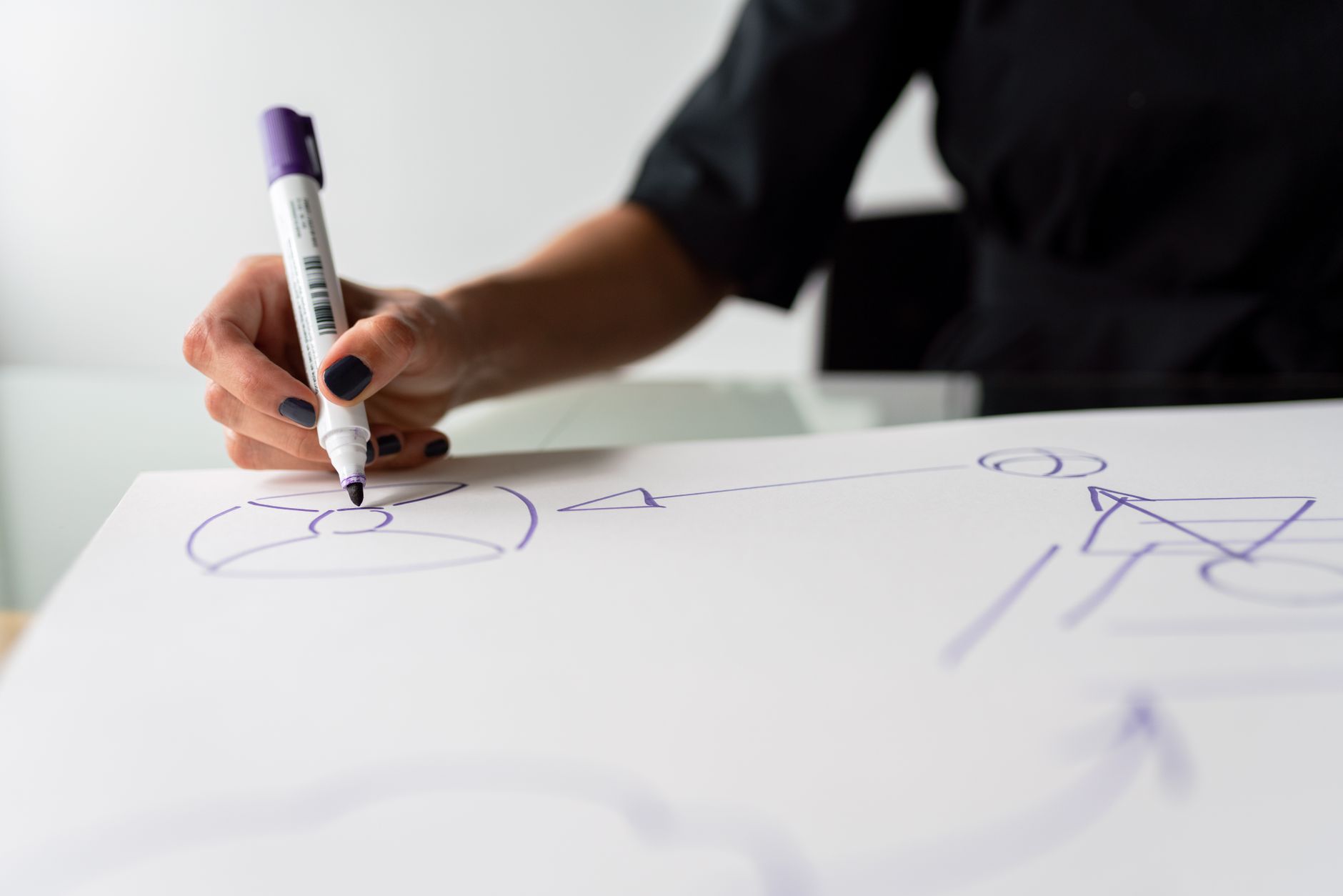 A focused view of a hand drawing with a marker on a paper, c