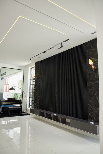 Sleek modern interior featuring a black accent wall, piano c