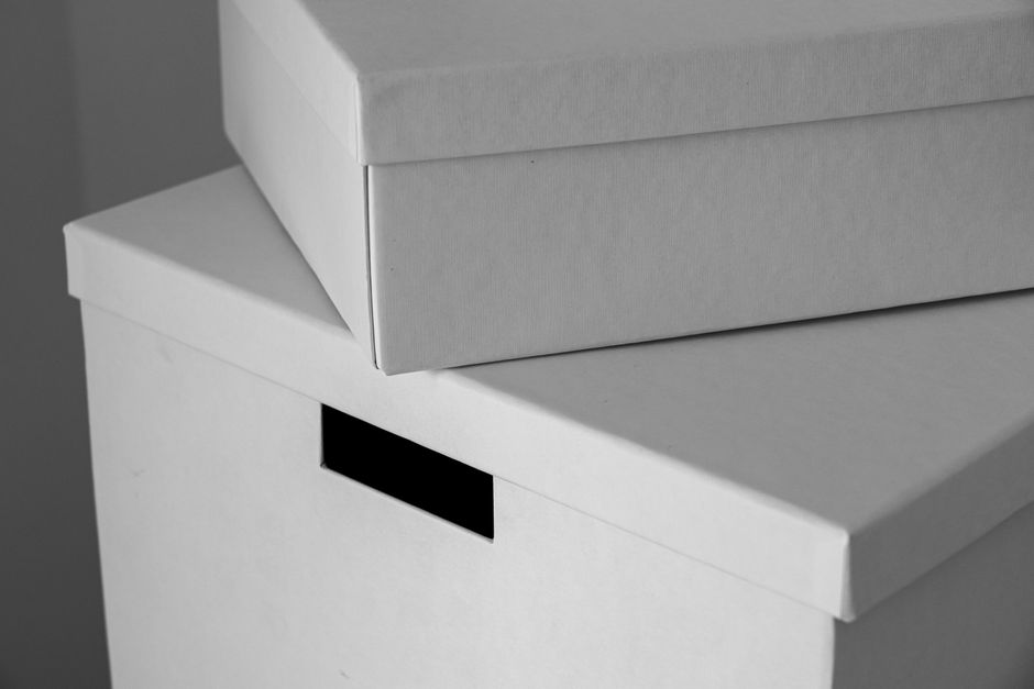 Close-up of minimalist white cardboard boxes stacked with am
