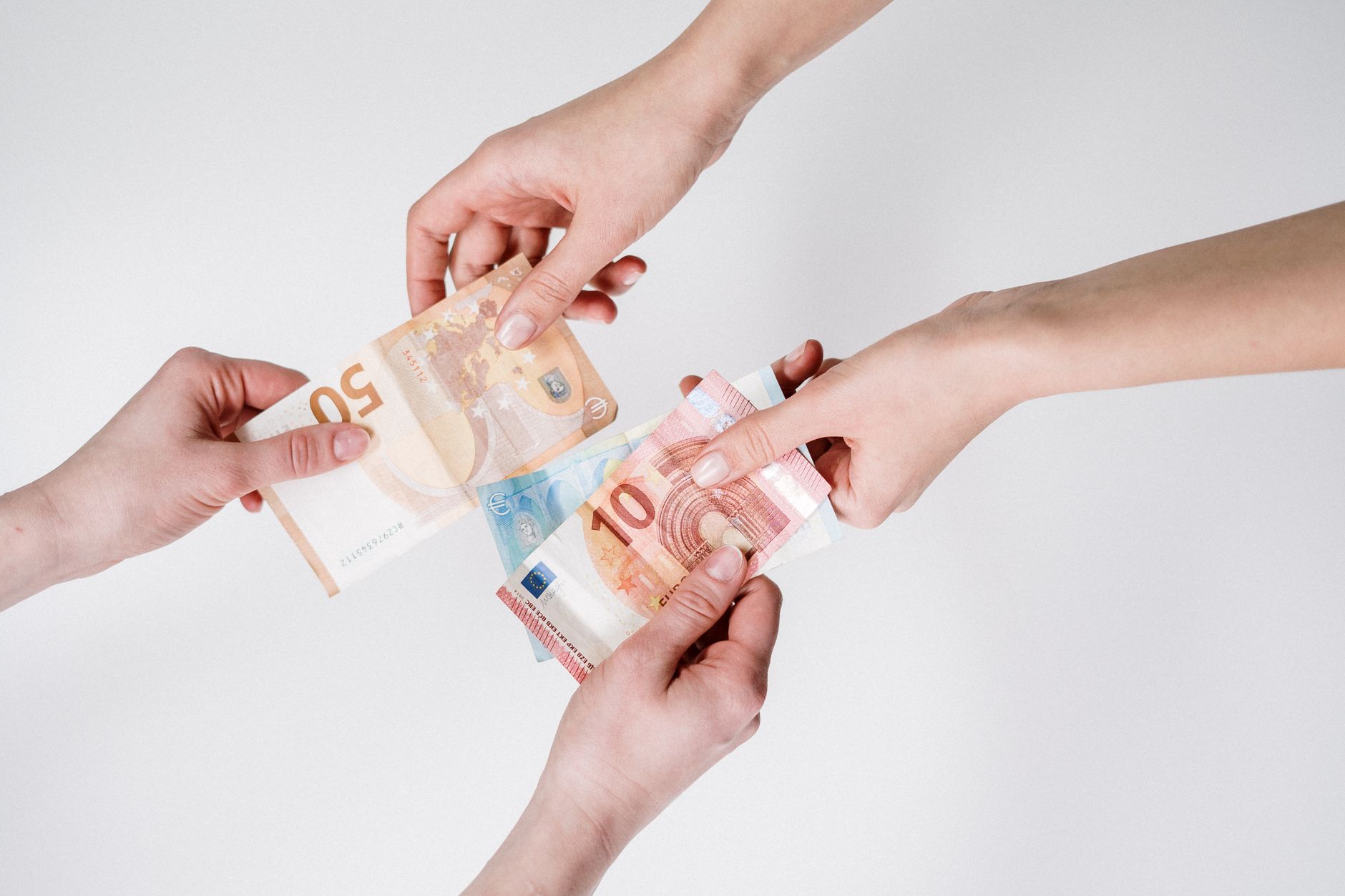 Two pairs of hands exchanging Euro banknotes, symbolizing fi