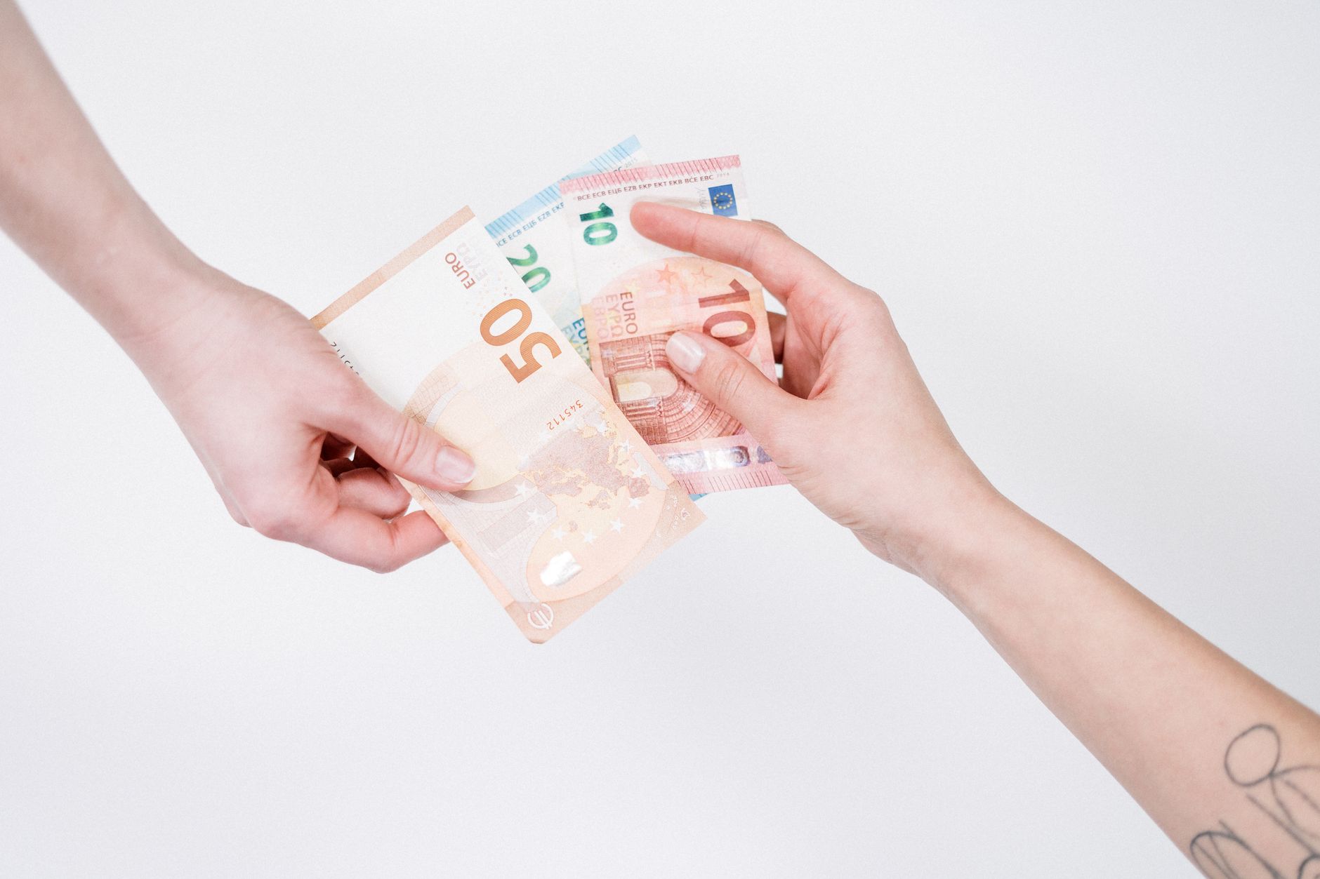 Close-up of hands exchanging euro banknotes, symbolizing fin