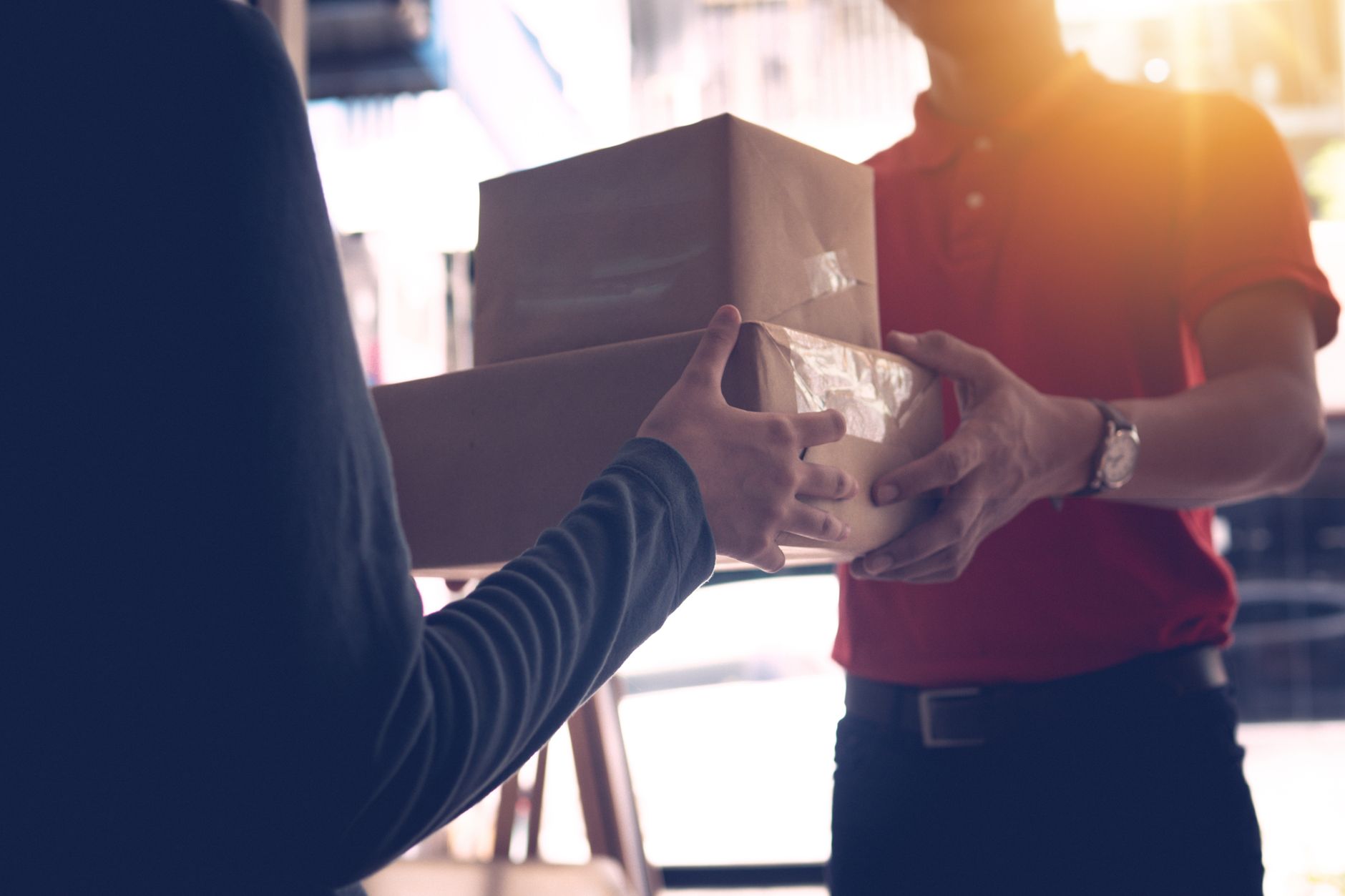 Close-up of a delivery service worker handing over packages