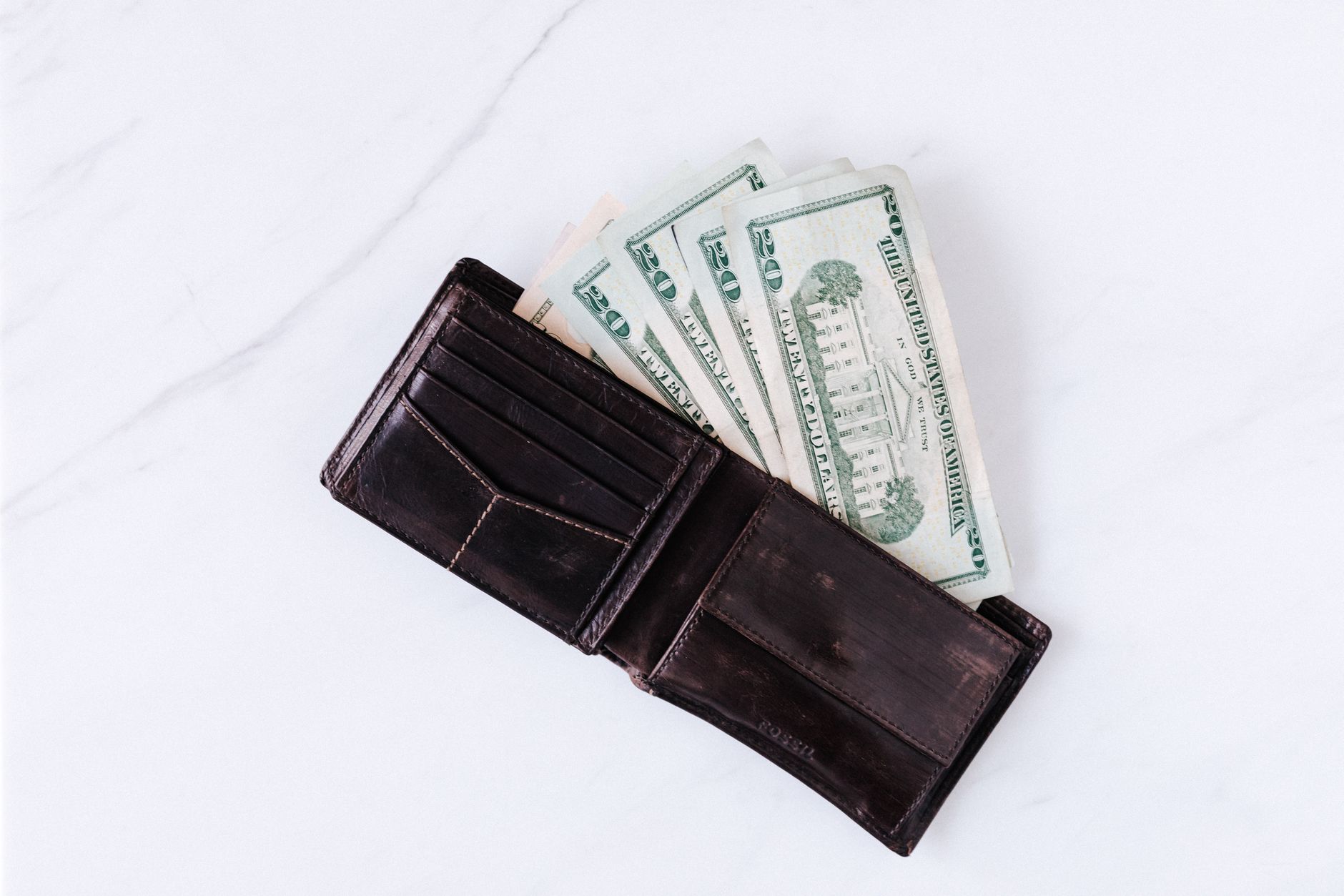 From above of black leather wallet with pockets filled with
