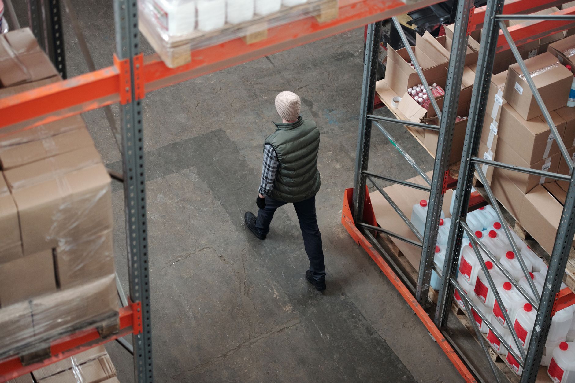 Overhead view of a worker walking through a warehouse aisle