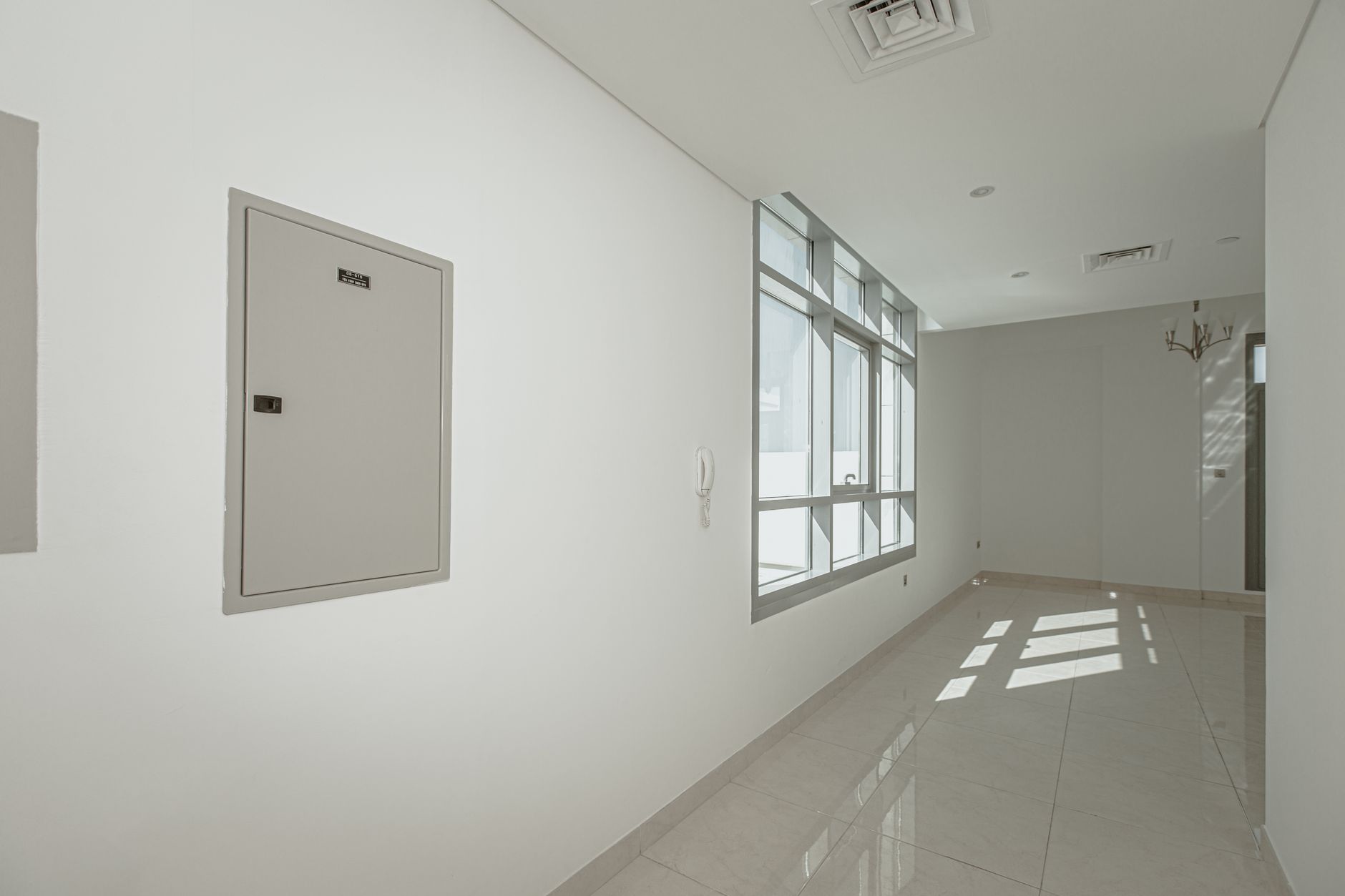 A clean, minimalistic empty corridor with natural light stre