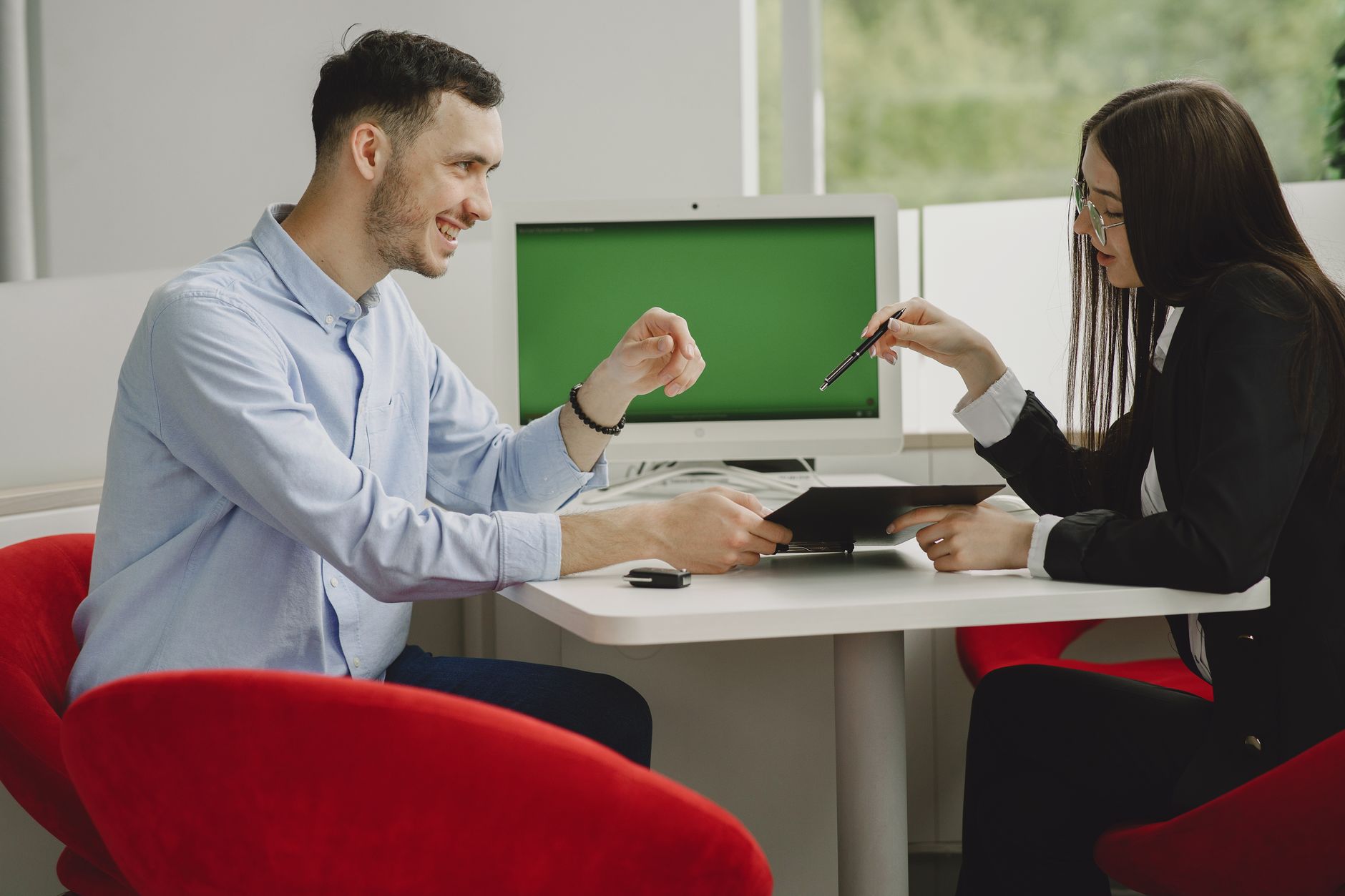 Two professionals engaged in a business discussion at a modern office desk.