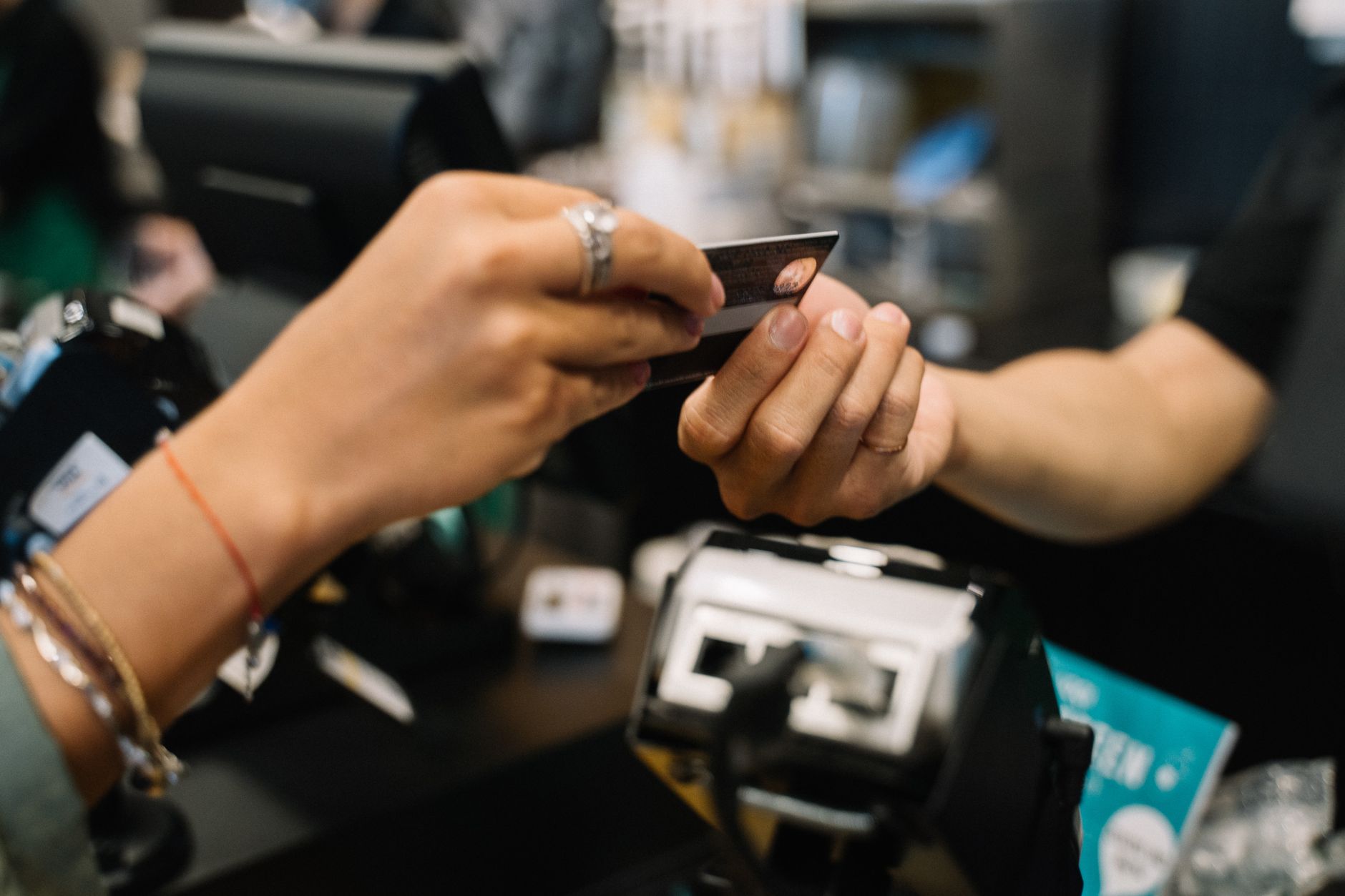 Close-up of hands completing a payment transaction at a reta