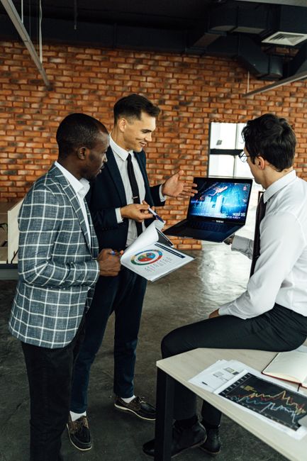 Three business professionals discussing financial charts in