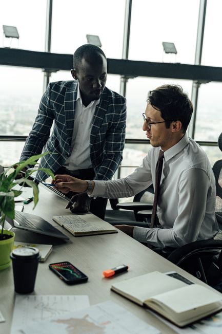 Two businessmen discussing projects in a modern high-rise of