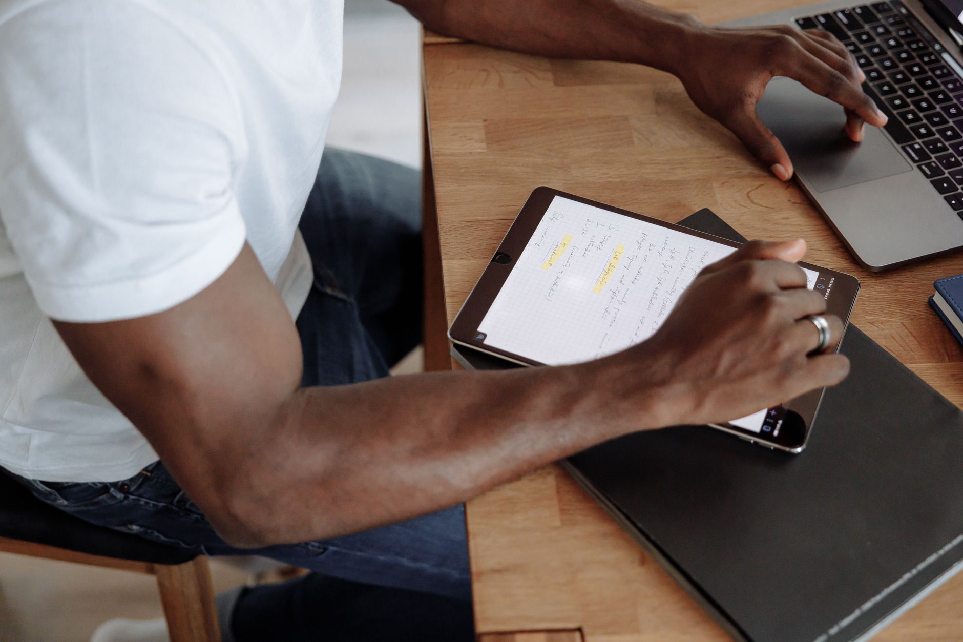 A freelancer working at home with a tablet and laptop, highl