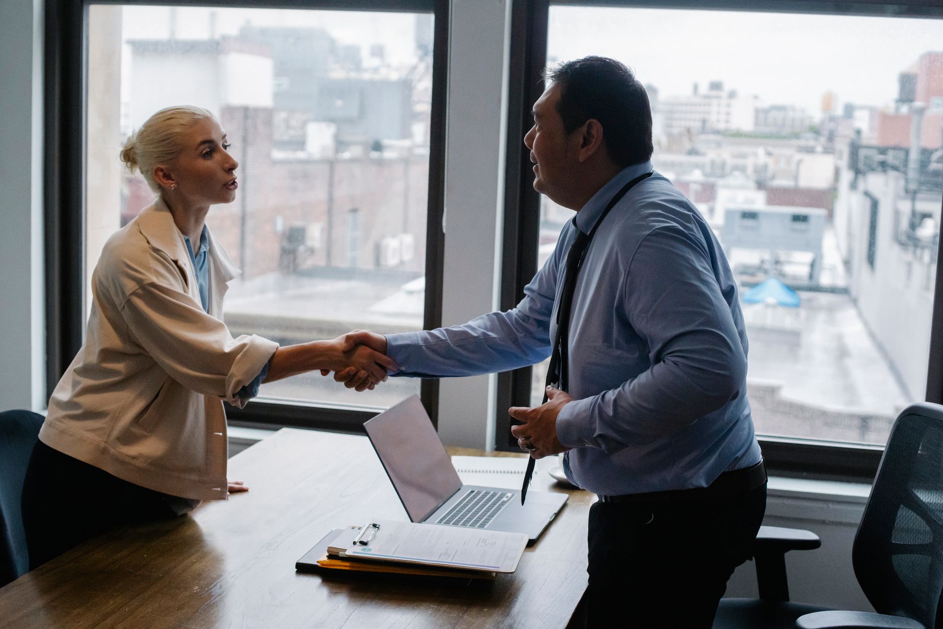 Young female candidate shaking hands with employer before jo