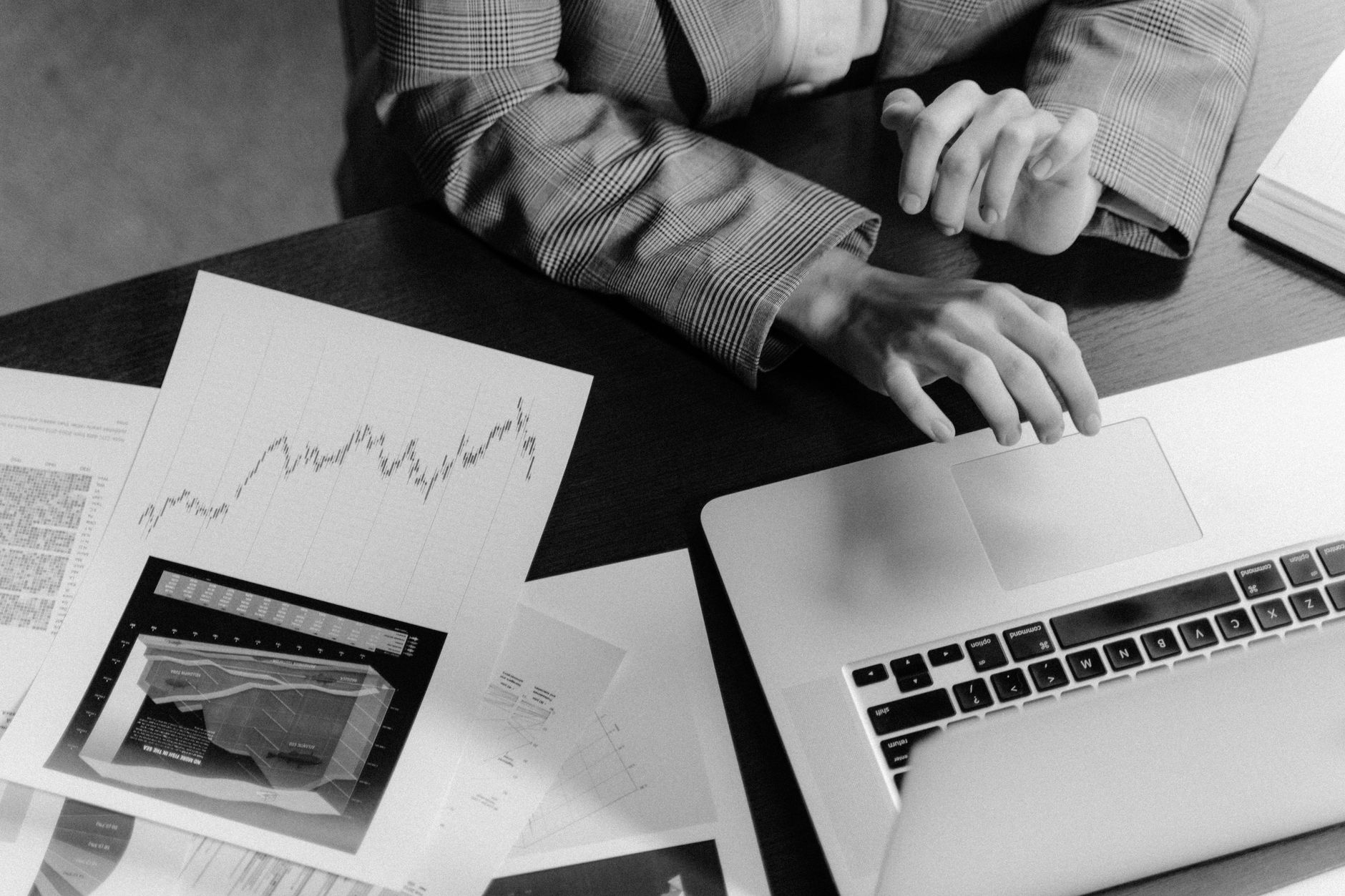 Focused workspace with business charts and laptop for financial analysis.