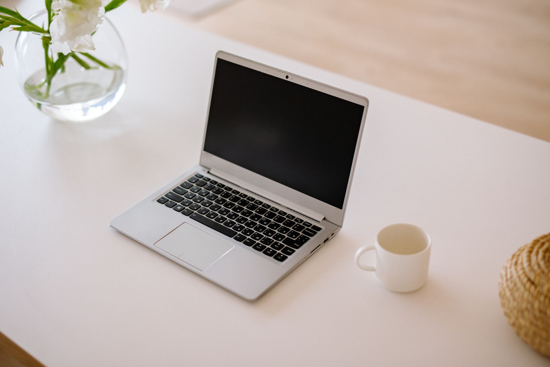 A minimalist workspace with an open laptop, coffee mug, and