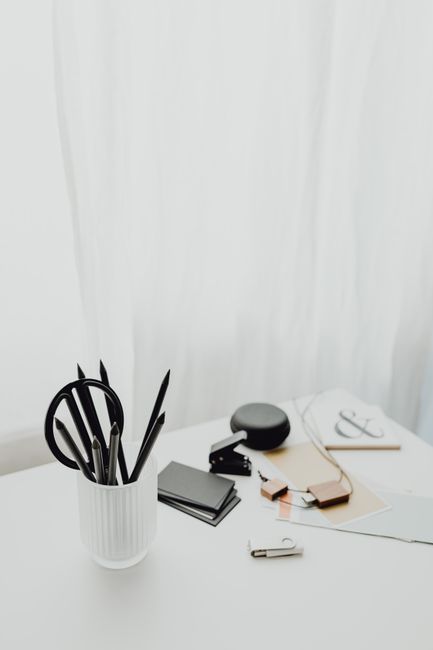 Minimalist office supplies on a white desk with a neutral ba