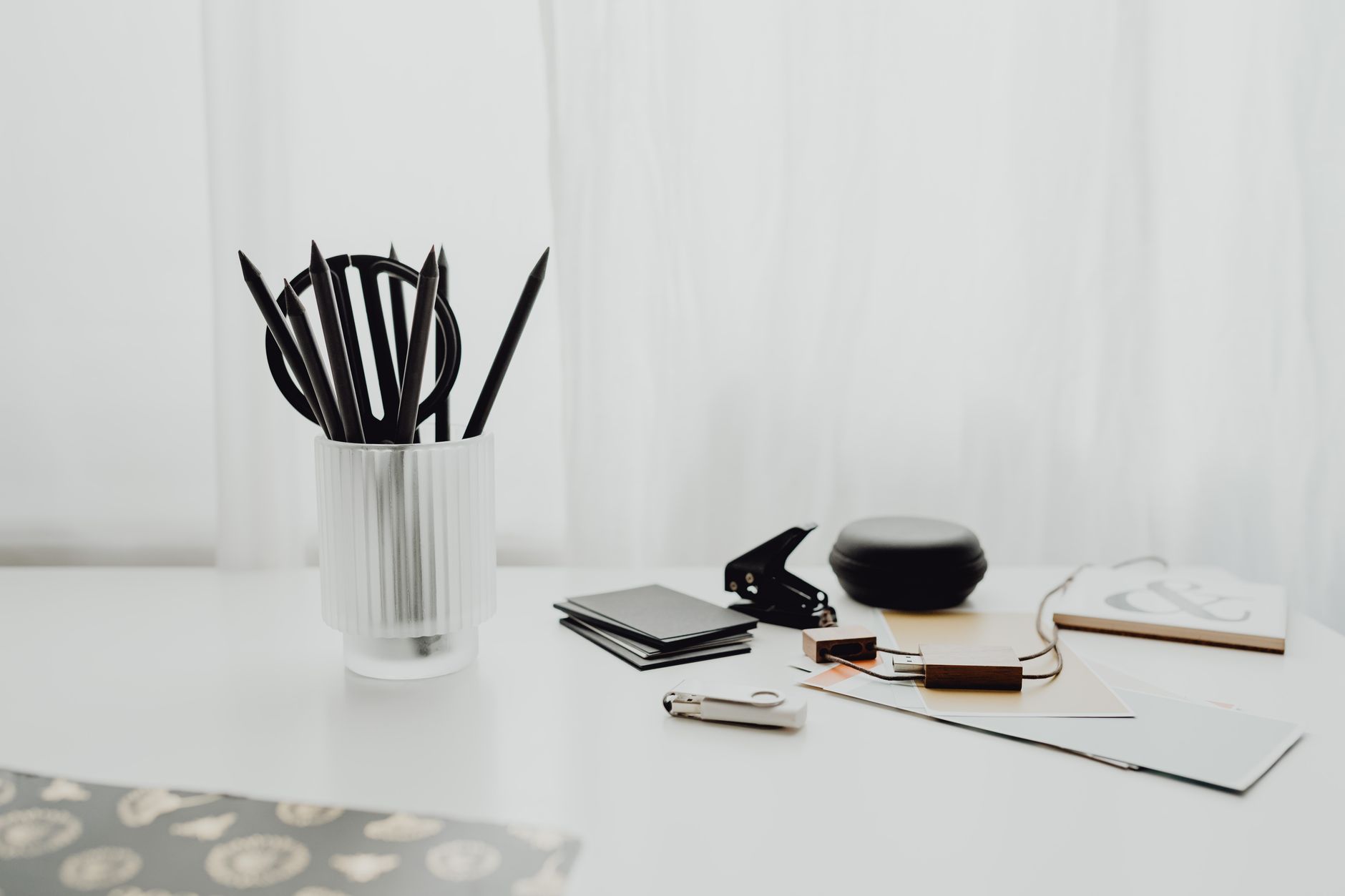 A clean white desk setup with office supplies and stationery