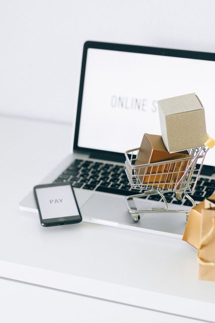 Mini shopping cart on laptop symbolizing online shopping and