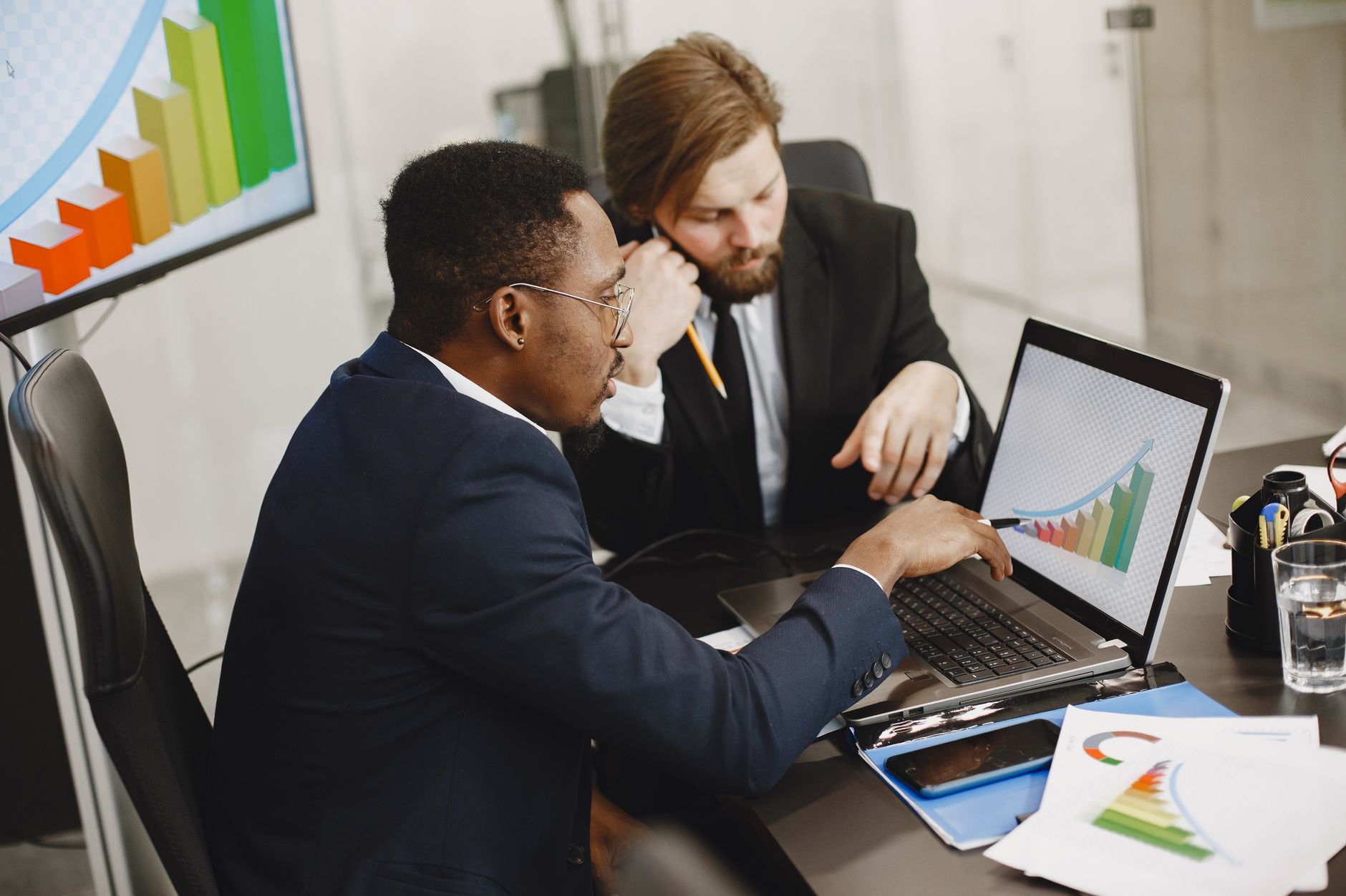 Two business professionals working on growth charts using la