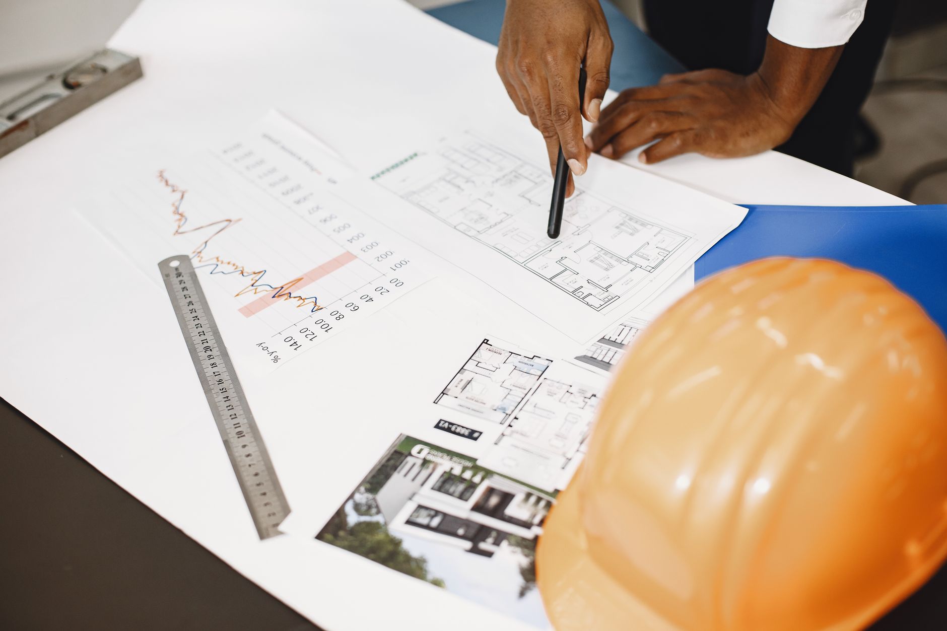Architect analyzing building blueprints with tools on a desk