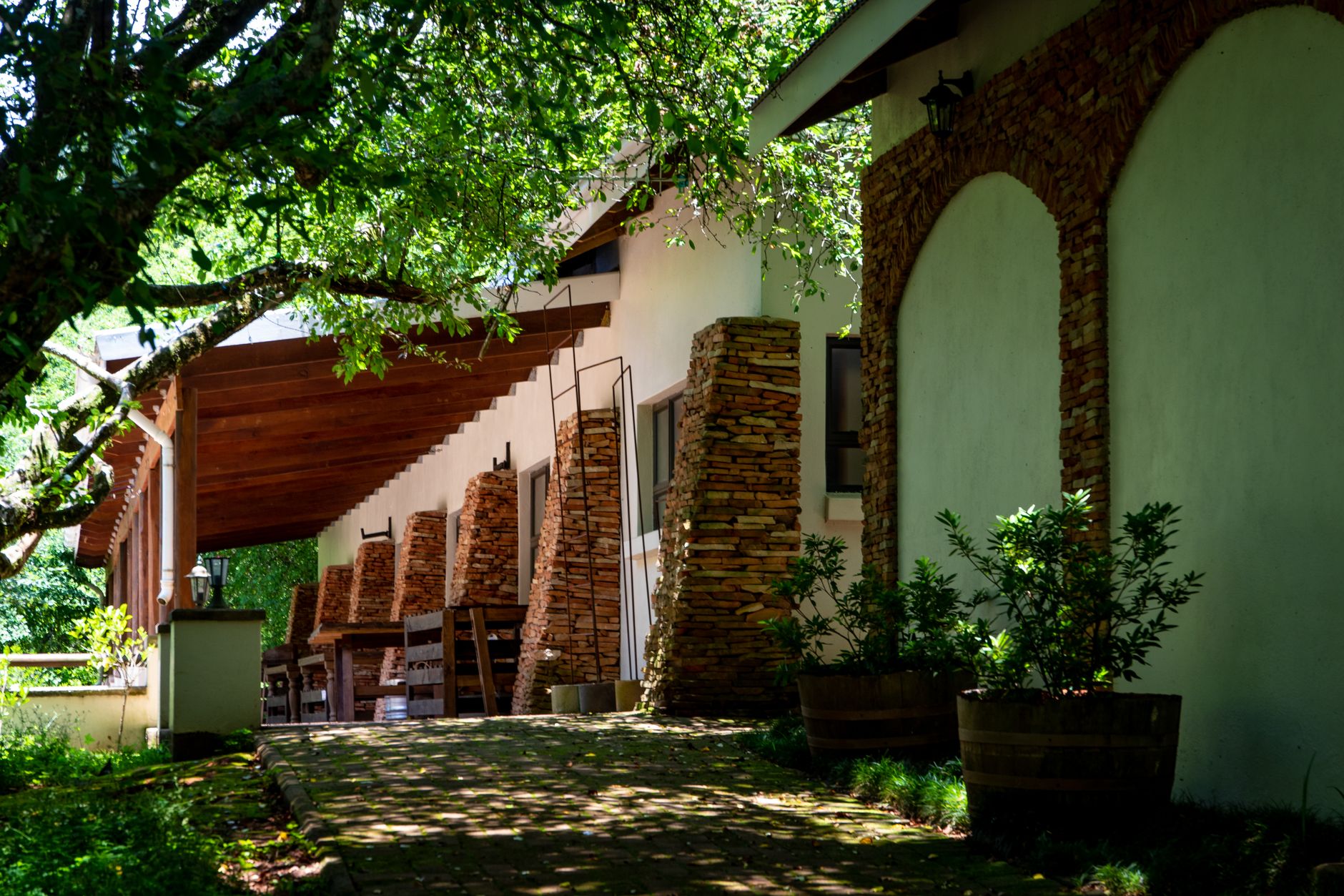 Rustic stone house porch with wooden features, surrounded by