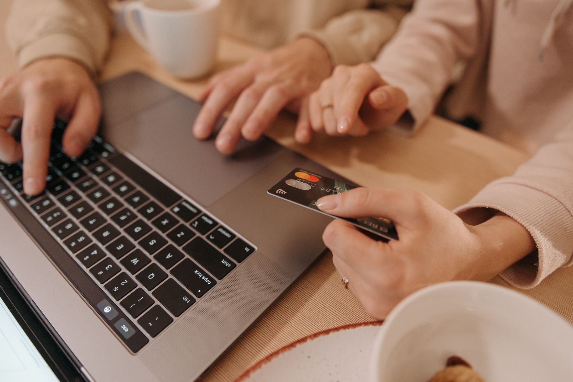 Close-up of hands using a laptop and credit card for an onli
