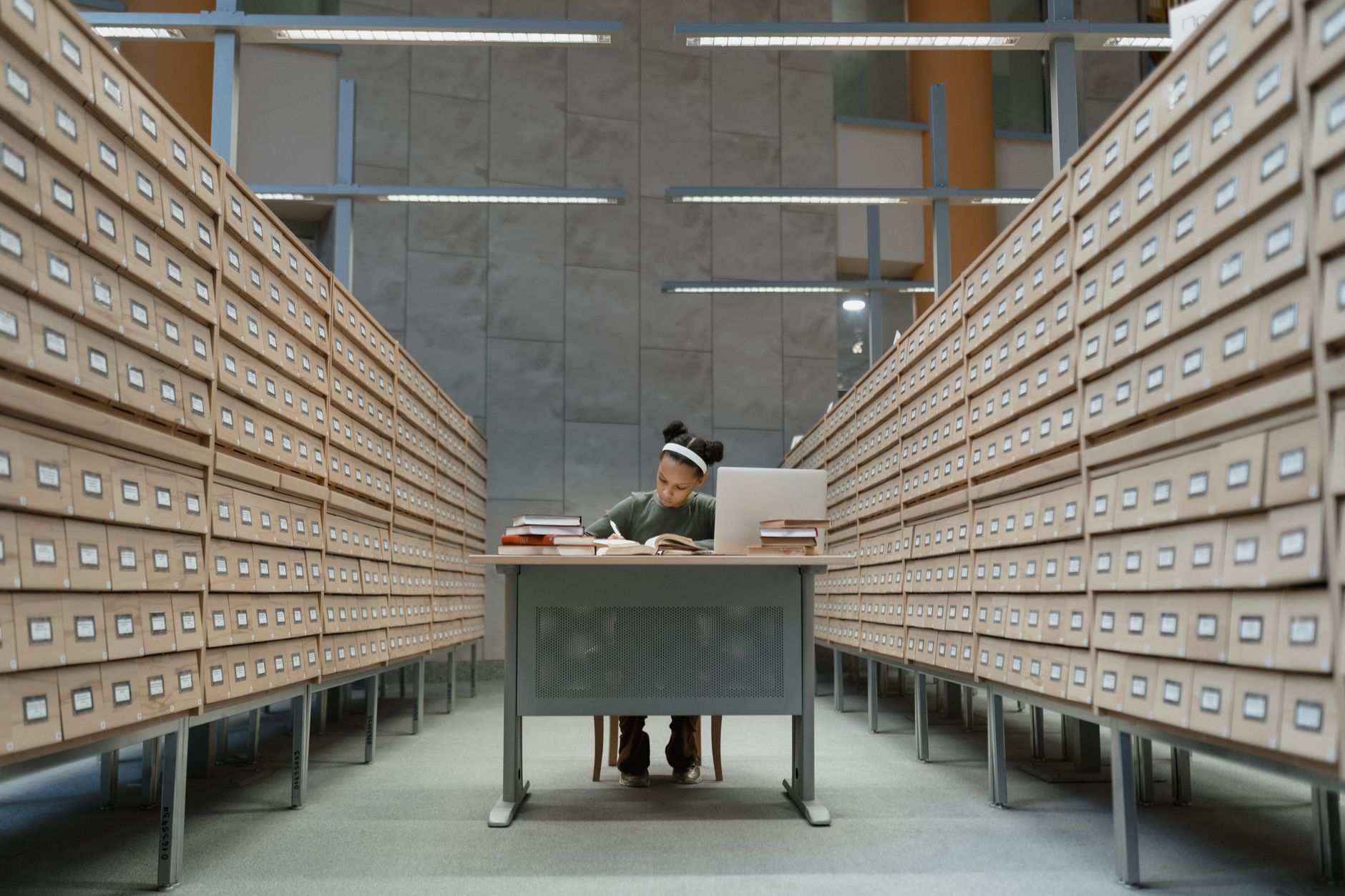 A student deeply focused on studying at a desk surrounded by