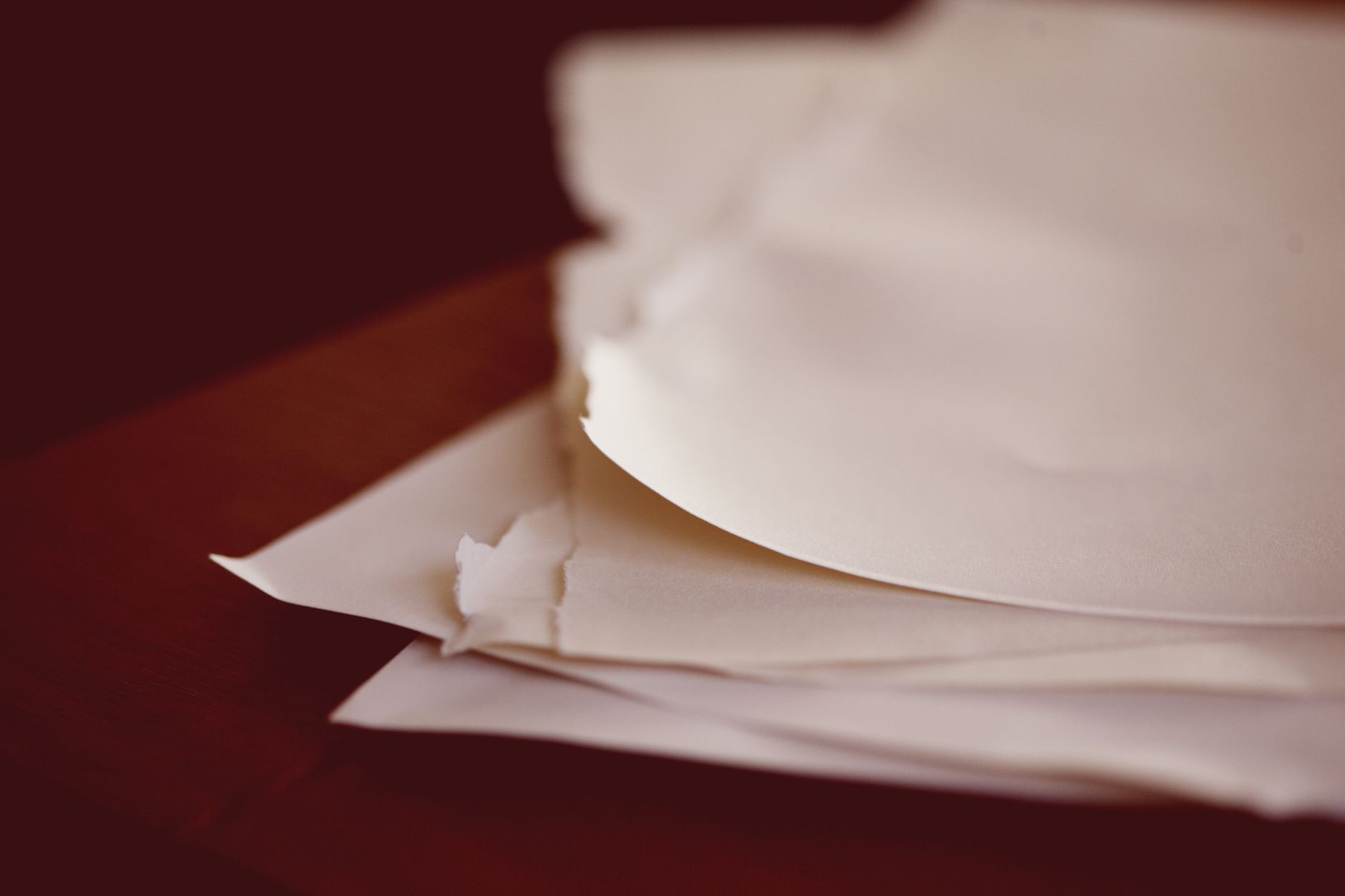 A close-up view of torn papers stacked on a desk with a blur