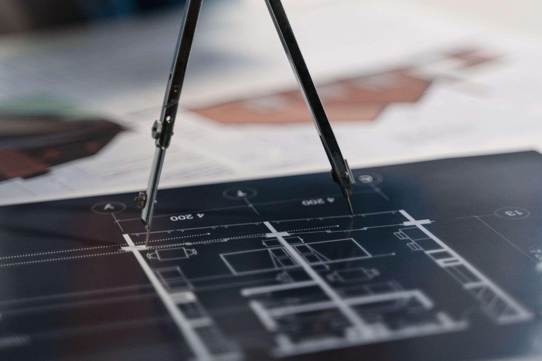A compass on architectural blueprints, showcasing planning a