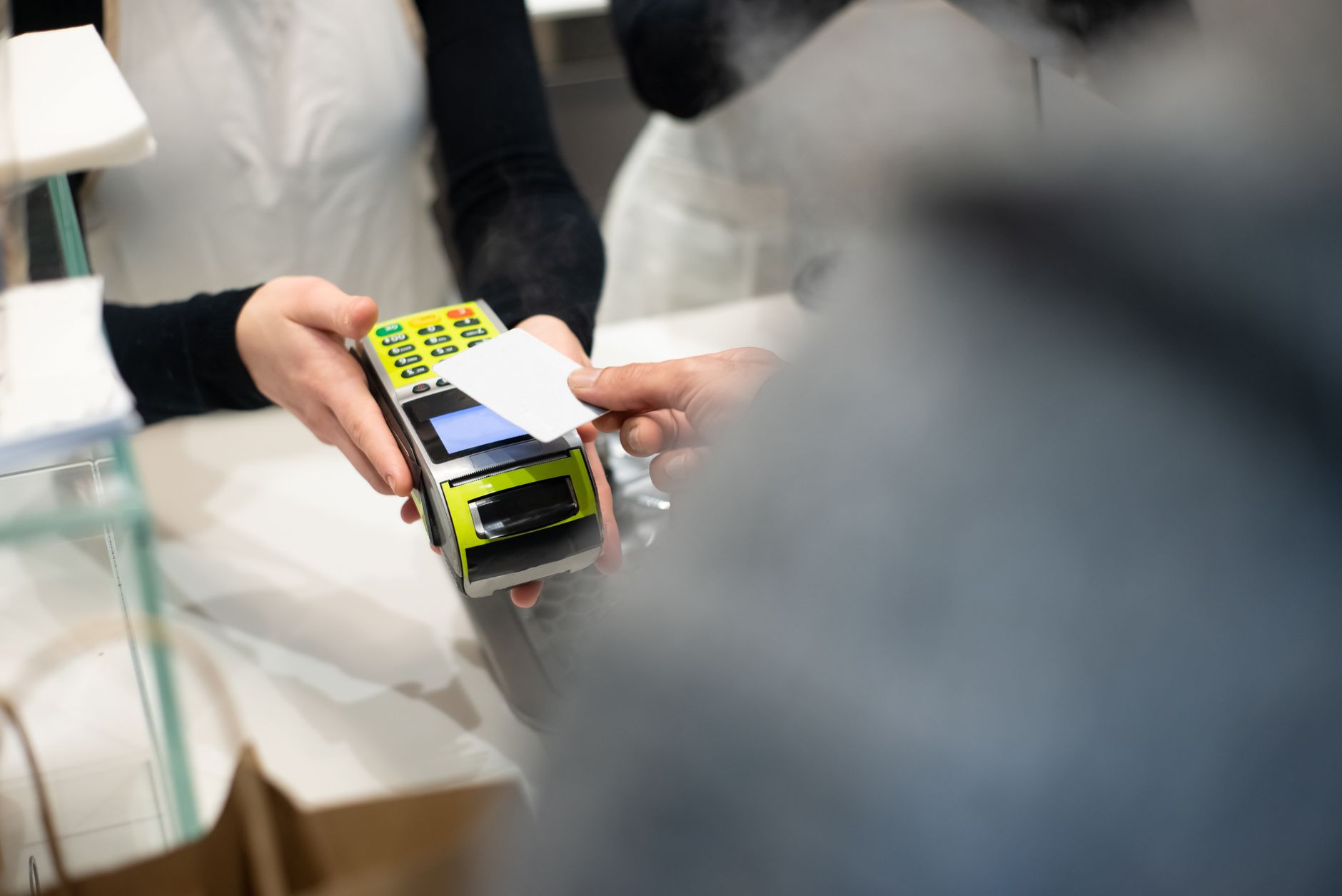 A customer pays with a card at a payment terminal in a moder