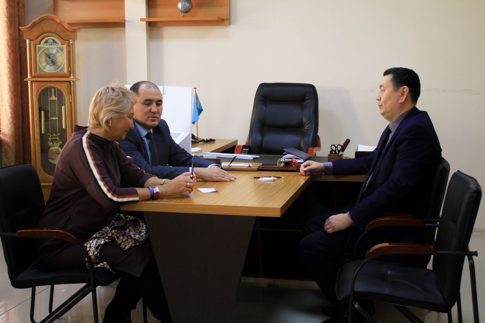 Executives discussing strategy around a conference table in a formal office environment.