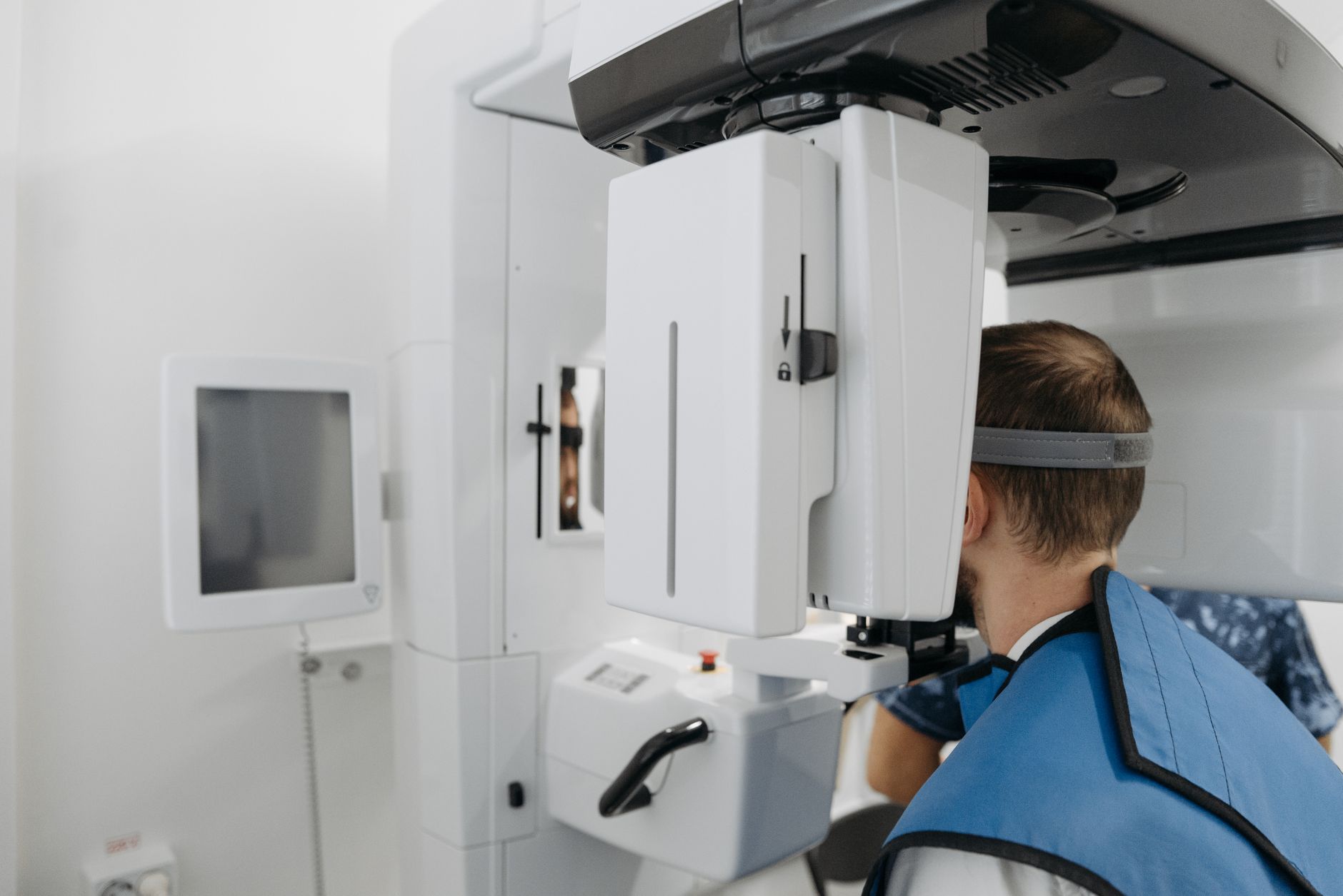 A patient undergoing a dental panoramic X-ray scan in a clin