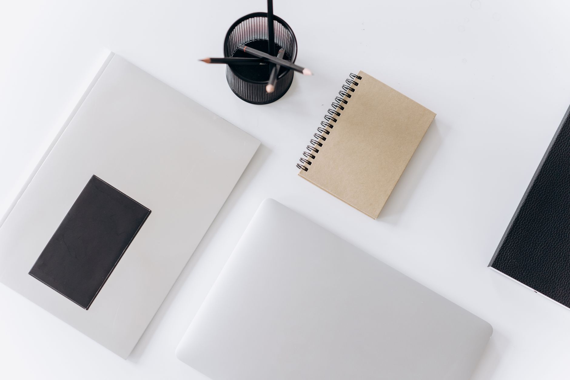 Top view of modern laptop with notebooks and cup of pencils