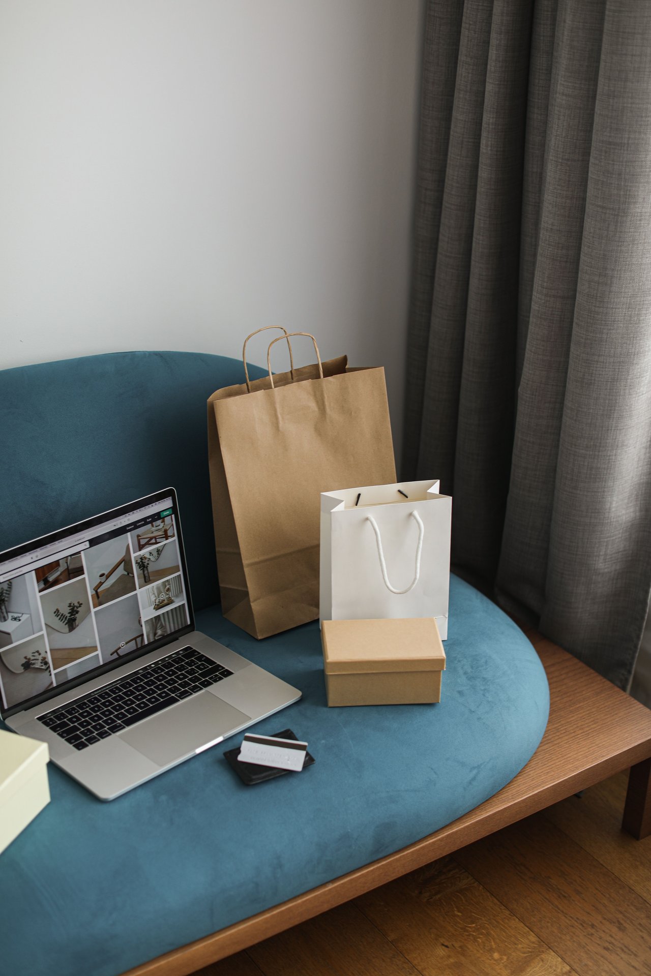 A cozy indoor scene featuring a laptop with shopping bags, representing modern online shopping.