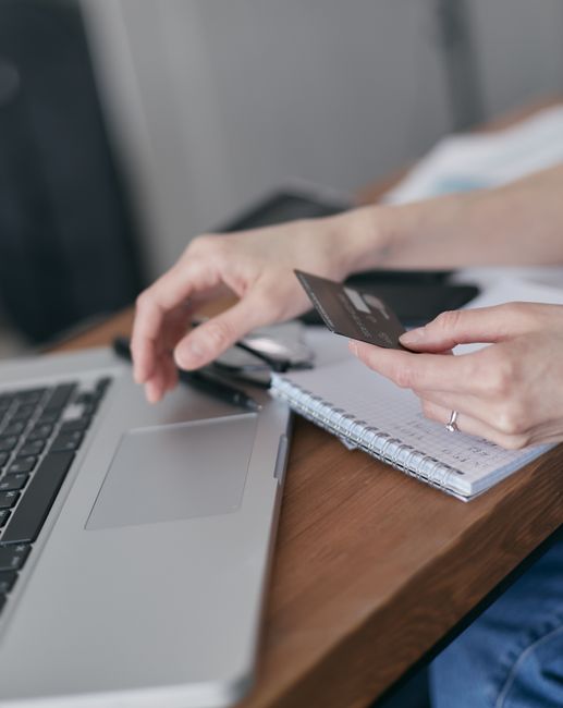 Close-up of hands holding credit card, shopping online using