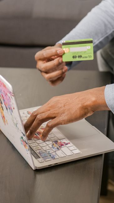Person using laptop for online shopping with credit card, focusing on digital payment.