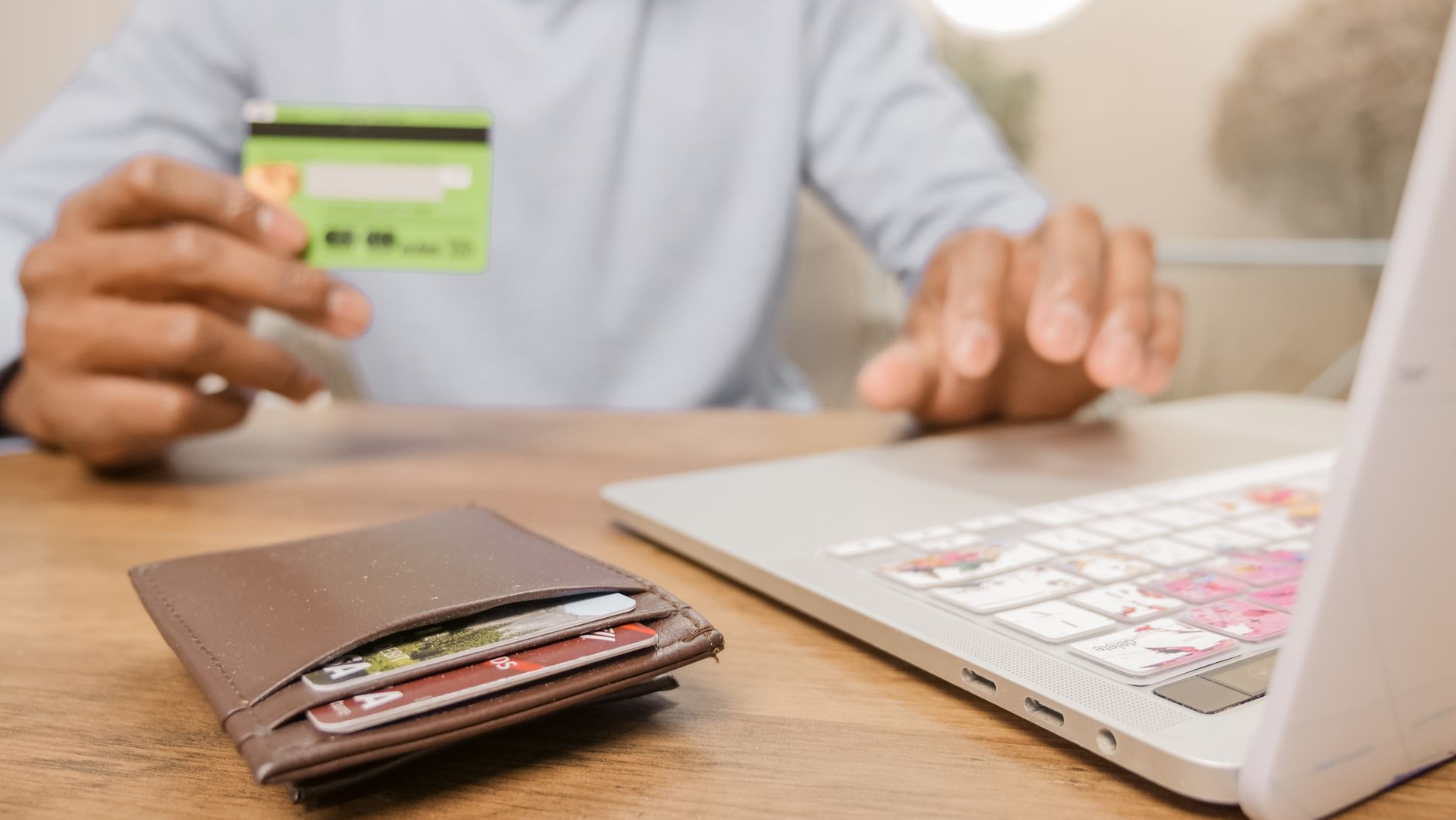 Close-up of hands with a bank card and laptop for online sho