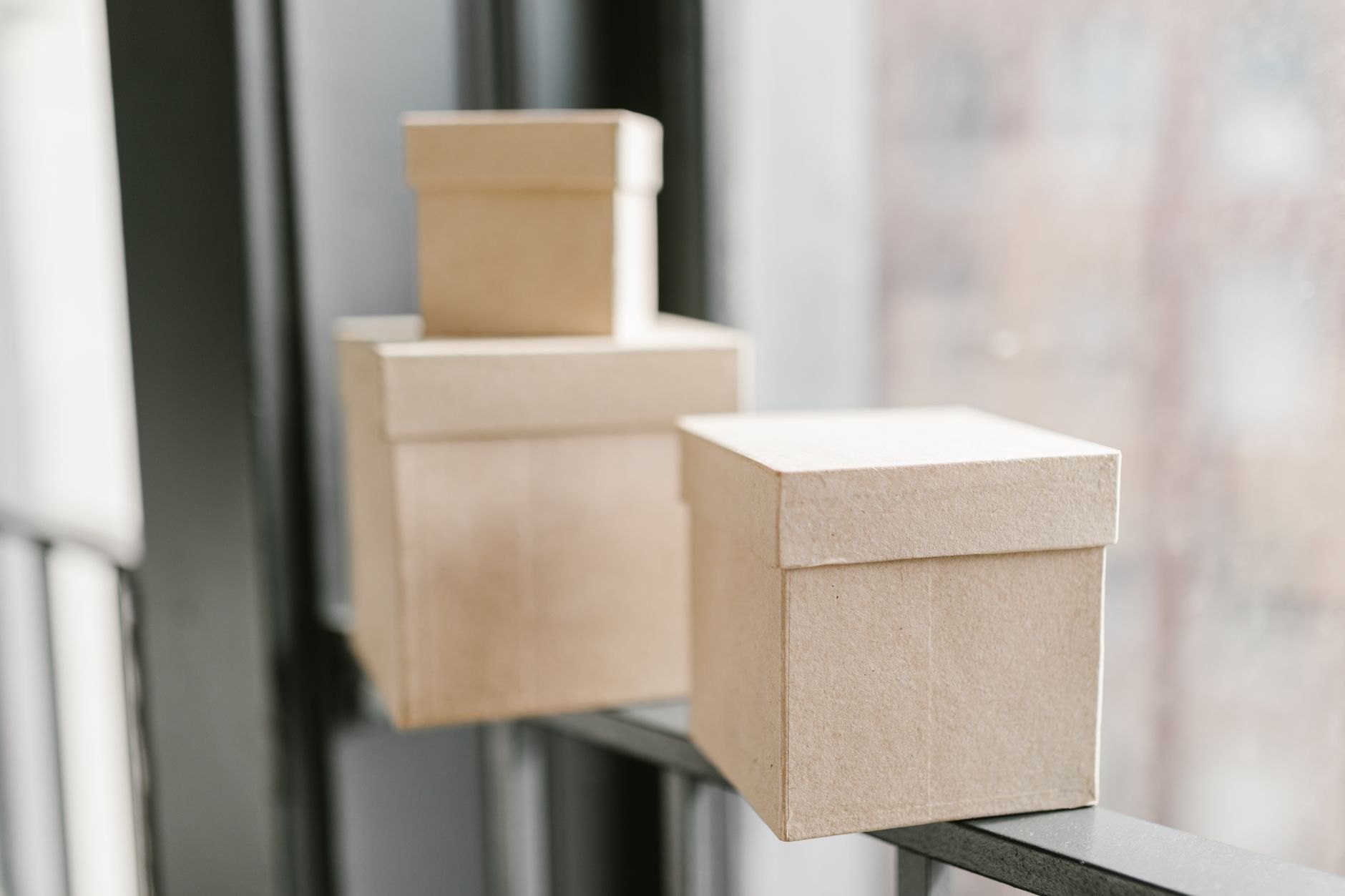 Simple cardboard boxes placed on a window sill with a blurre