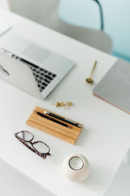 Clean and organized workspace featuring a laptop, eyeglasses