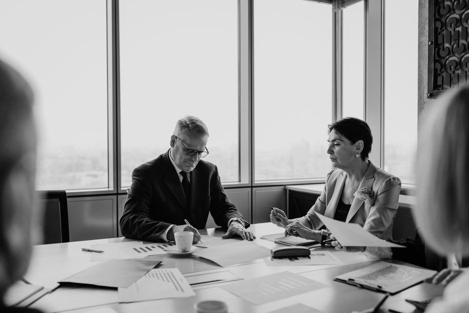 Black and white image of a business meeting with diverse pro