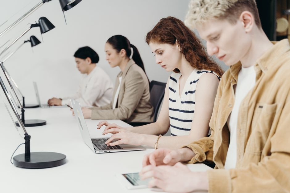 Diverse group of professionals working on laptops at a brigh