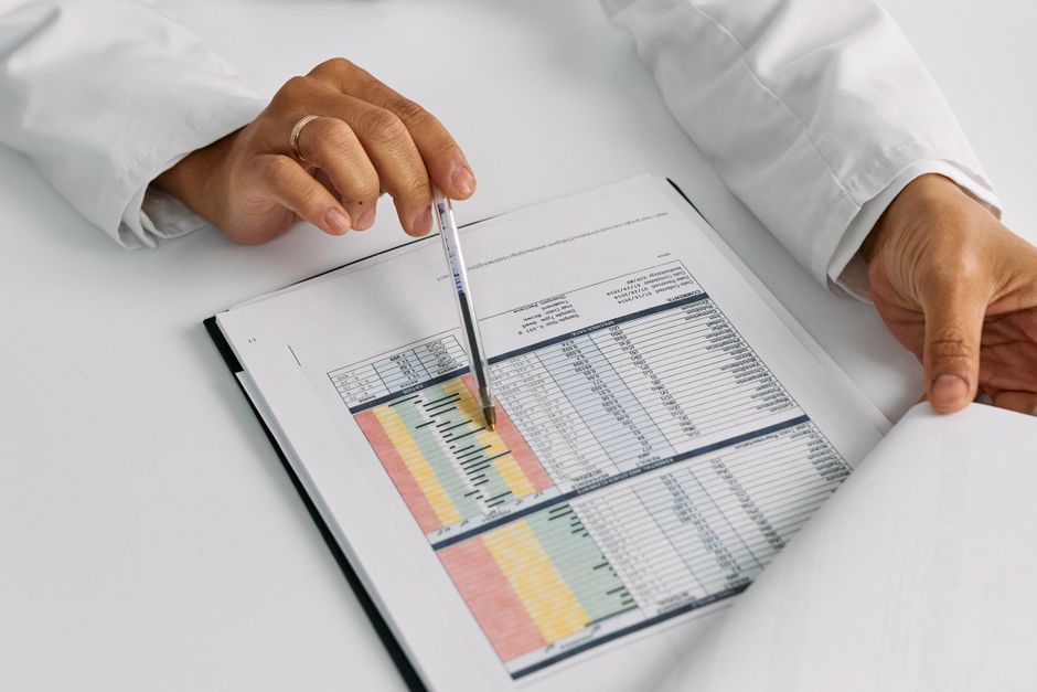 Doctor hands examining and pointing at medical charts in a c