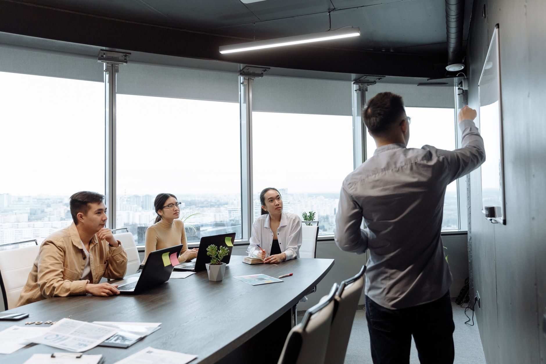 Colleagues in a meeting room discussing a presentation with