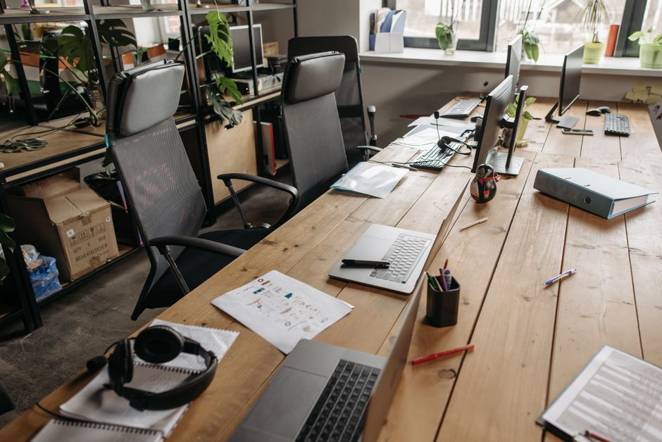Spacious co-working office with wooden desks, laptops, and m