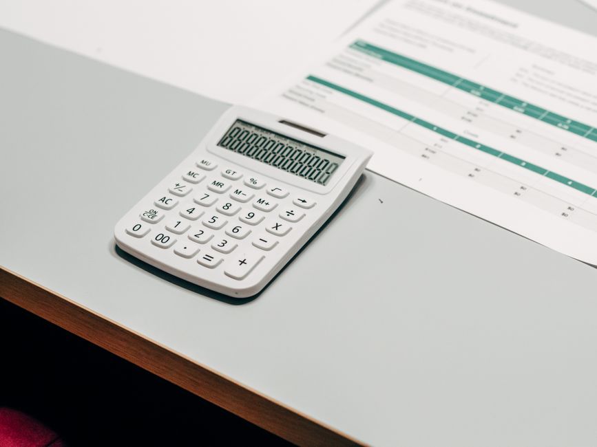 Close-up of a white calculator next to a financial spreadshe