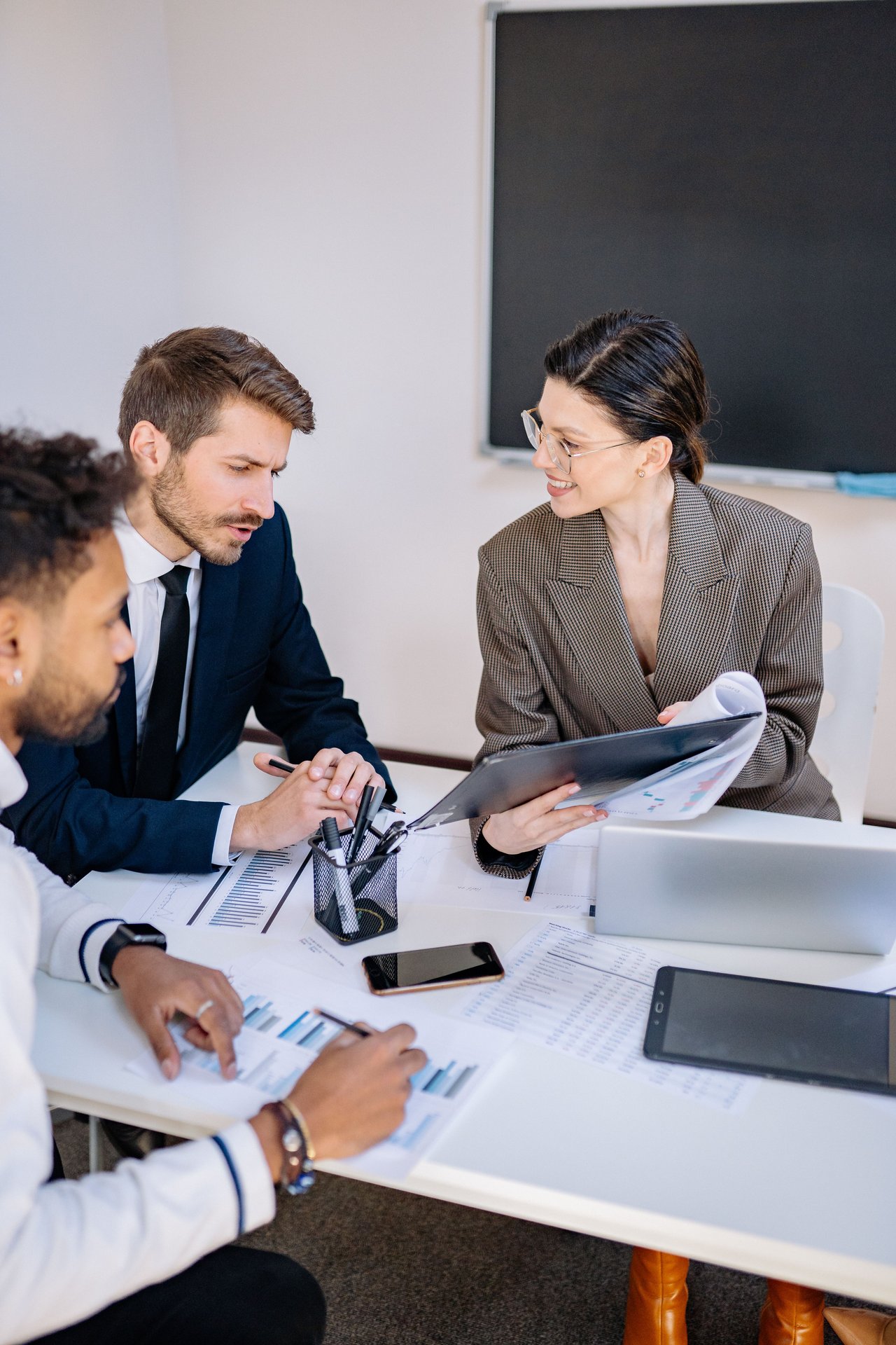Three professionals engaged in a productive office meeting s