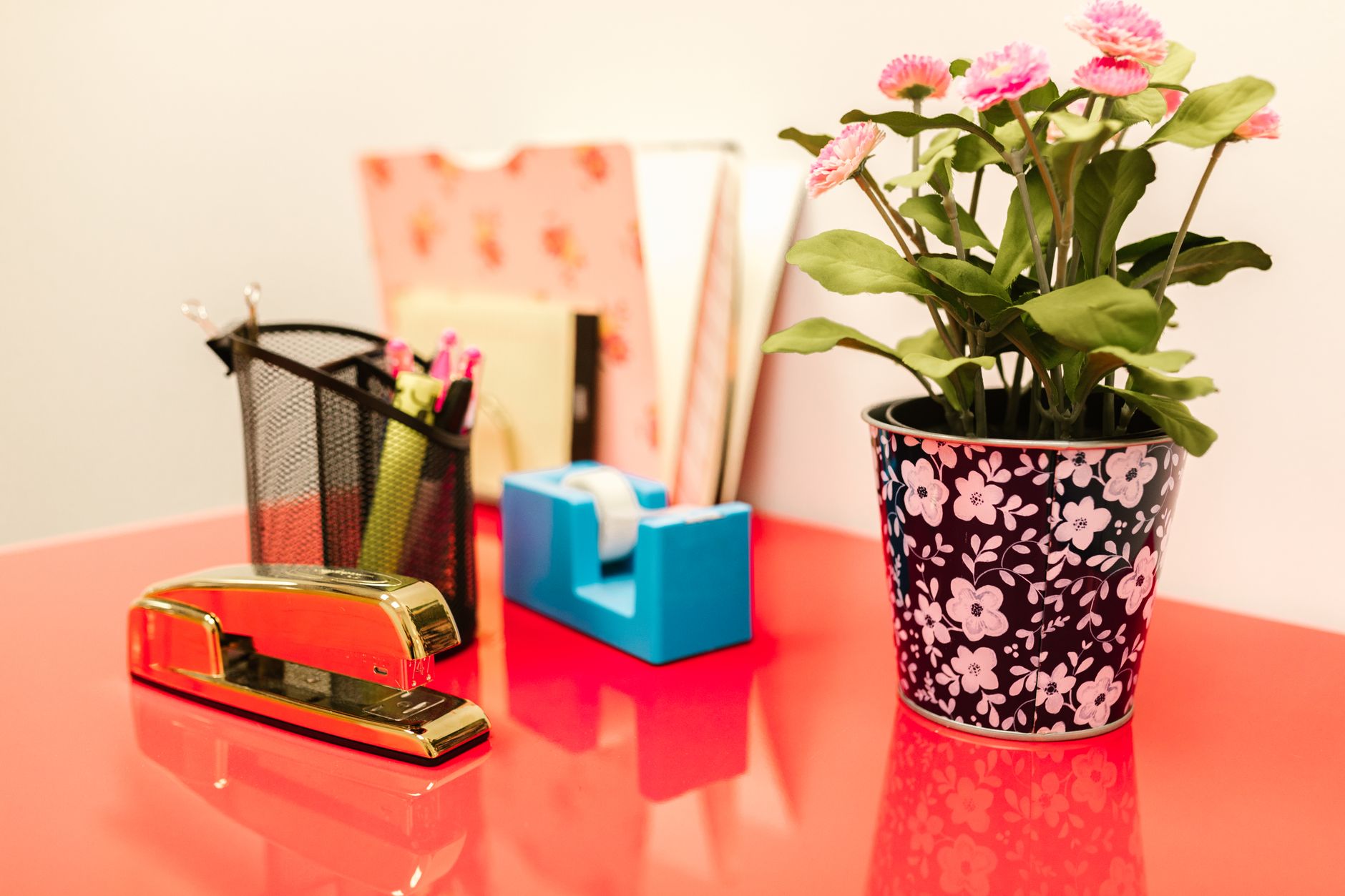 A vibrant desk setup featuring office supplies, a gold stapl