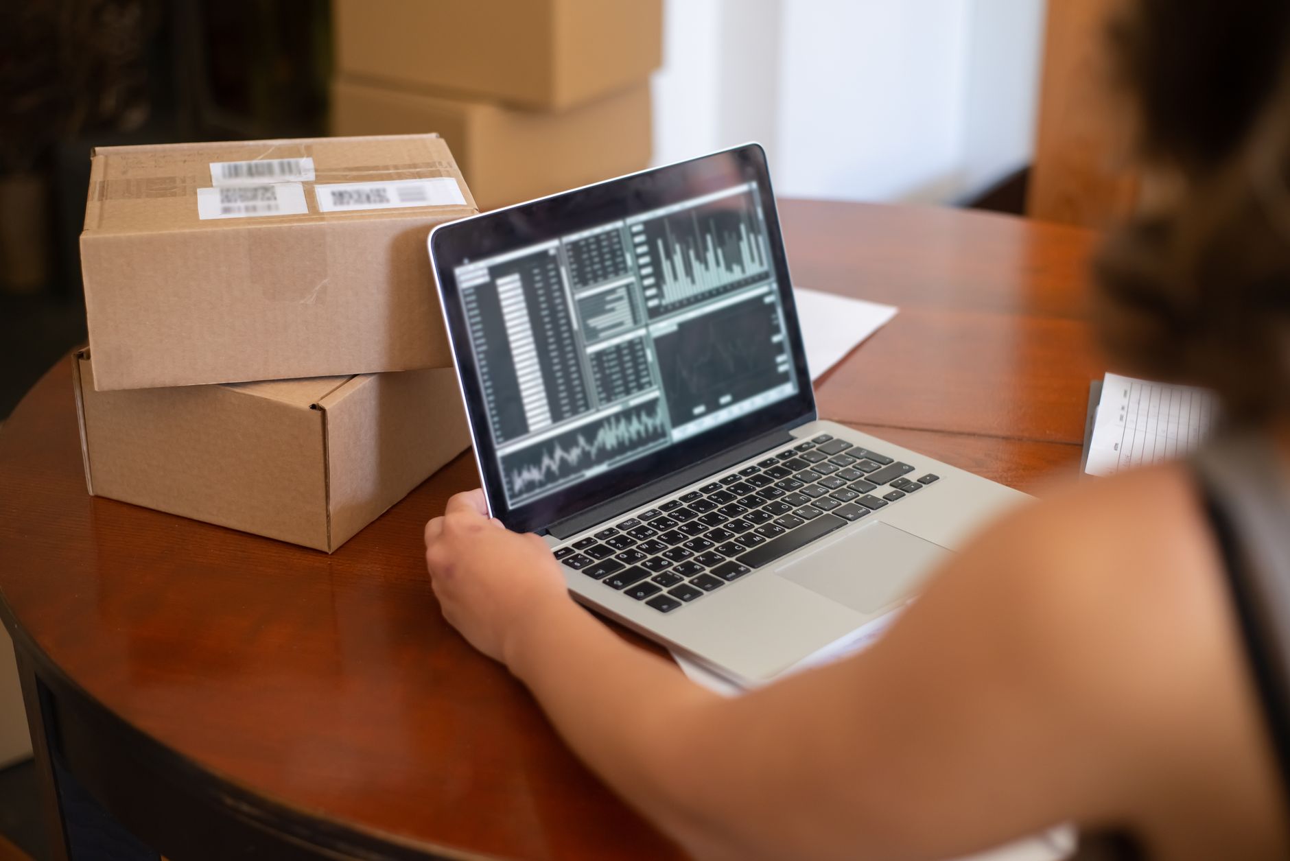 出荷する荷物のそばでパソコンを使って注文を管理する場面