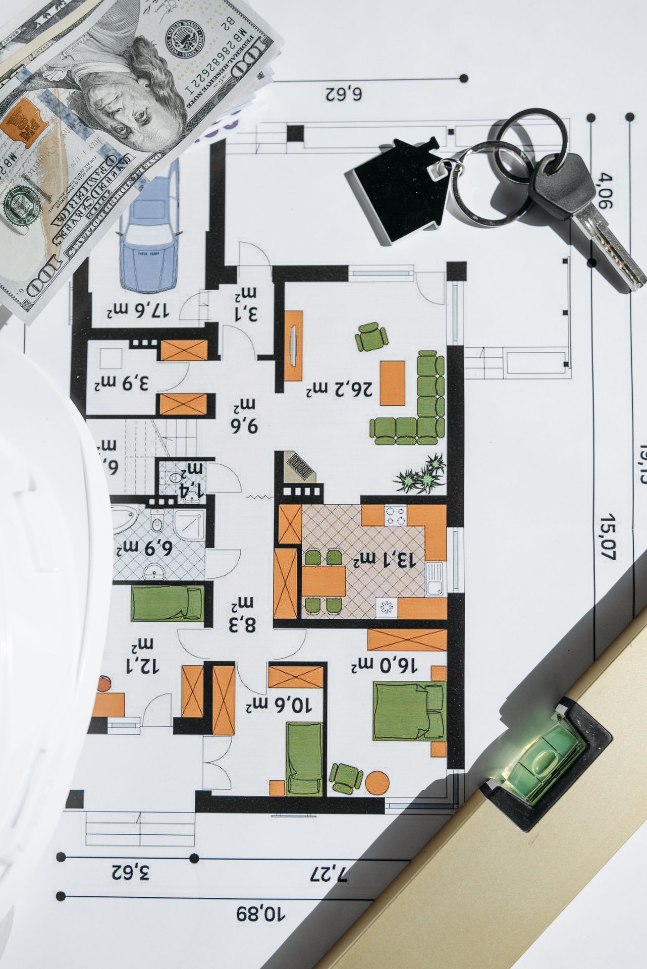 Overhead view of a house floor plan with keys and cash, symb